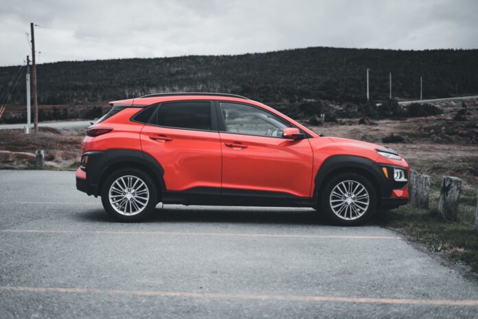 Czerwone Mitsubishi ASX zaparkowane na zewnątrz w pochmurny dzień