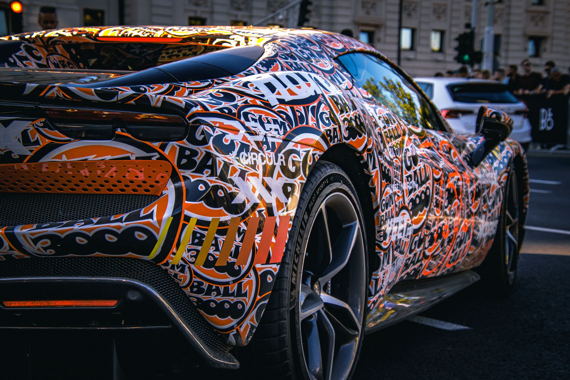 Ford Mustang z kolorowym graffiti na ruchliwej miejskiej ulicy