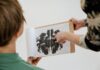 Badania psychotechniczne dla kierowców zawodowych: kiedy są wymagane i jak wyglądają krok po kroku Psycholog rozmawia z pacjentem, pokazując mu test plam atramentowych