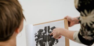 Psycholog rozmawia z pacjentem, pokazując mu test plam atramentowych