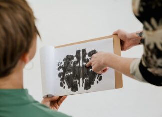 Psycholog rozmawia z pacjentem, pokazując mu test plam atramentowych