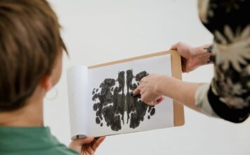Psycholog rozmawia z pacjentem, pokazując mu test plam atramentowych