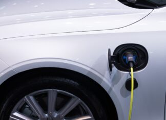 Białe auto elektryczne Toyota podłączone do ładowania, zbliżenie gniazda